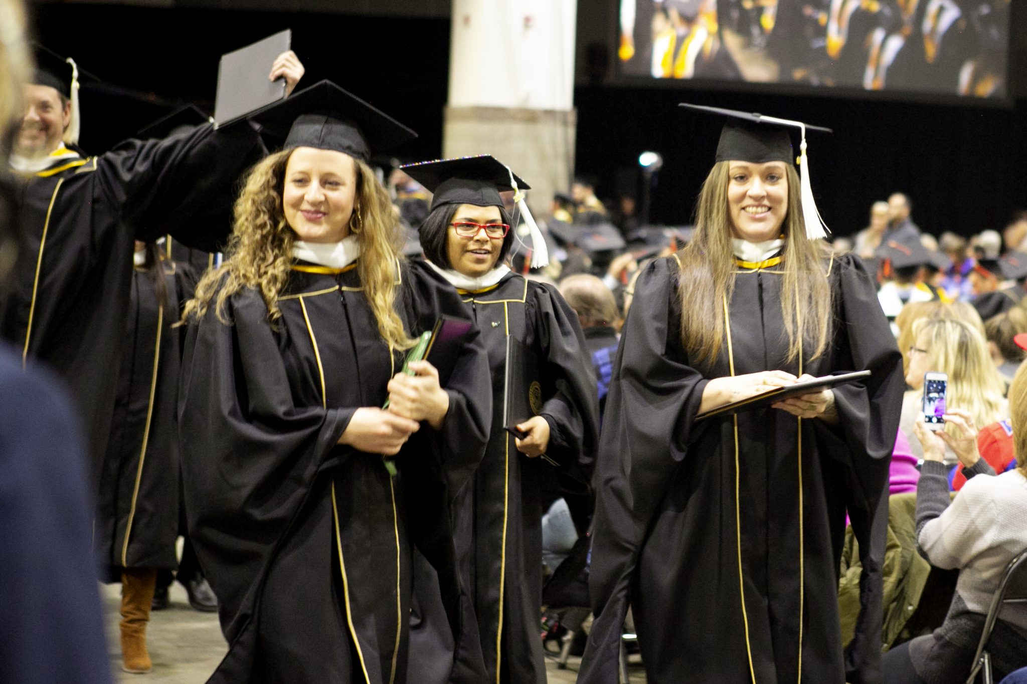 SEHD grads walking down isle after receiving diploma during fall commencement 2018