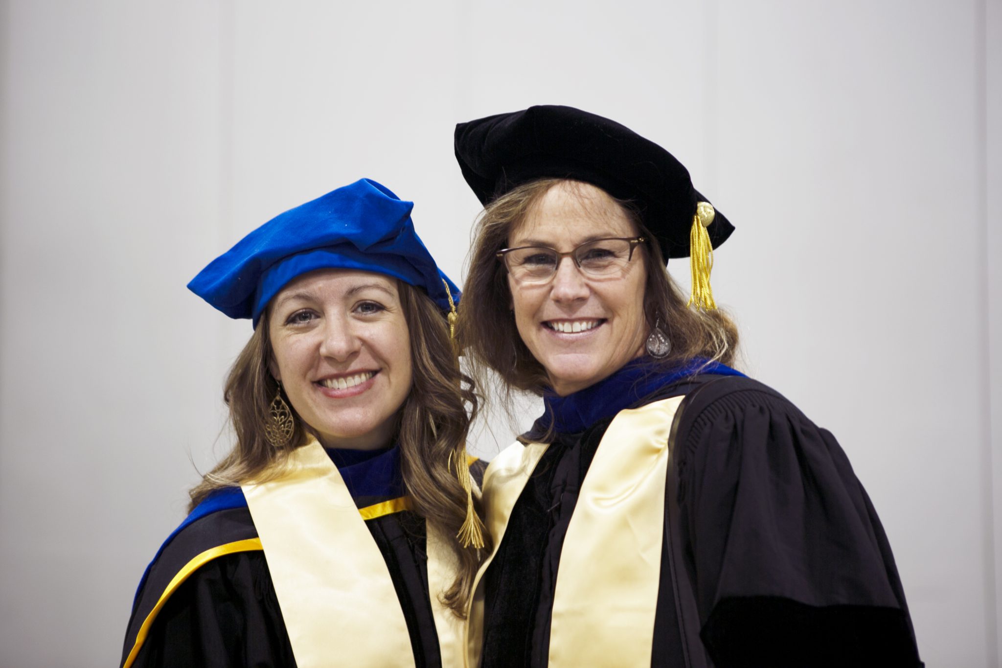Image of two female SEHD faculty members wearing grad regalia during fall commencement 2018